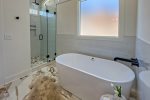 Quartz vanity, tile walk-in shower, luxury ceramic soaking tub